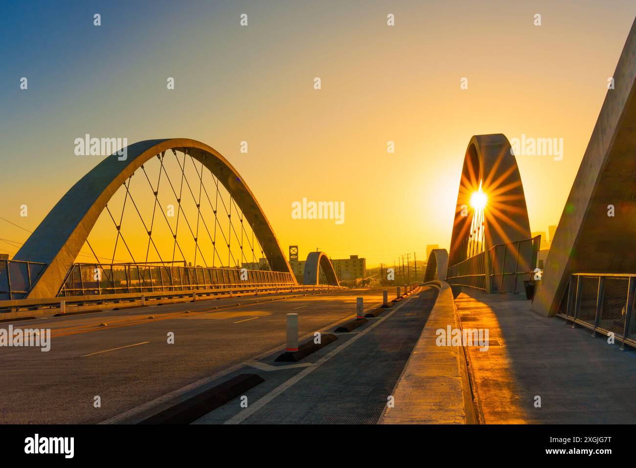 6th Street Bridge a Los Angeles catturato durante il tramonto, con la calda luce del sole che sbircia attraverso gli archi. Foto Stock