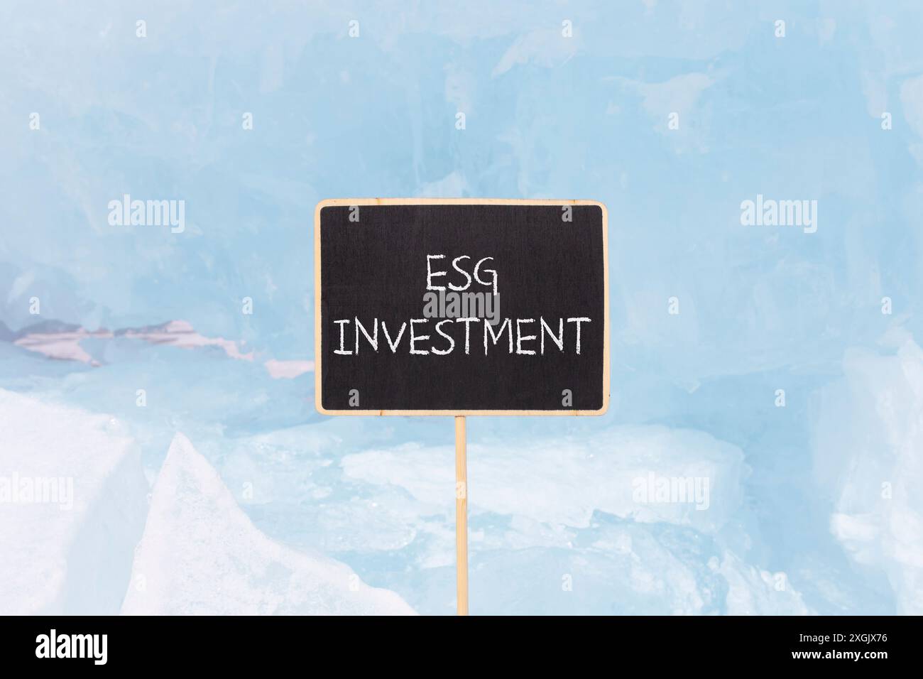 Simbolo di investimento per la governance sociale ambientale ESG. Parole concettuali investimento ESG su una bellissima lavagna nera gialla. Un bel backgroun blu di ghiaccio Foto Stock