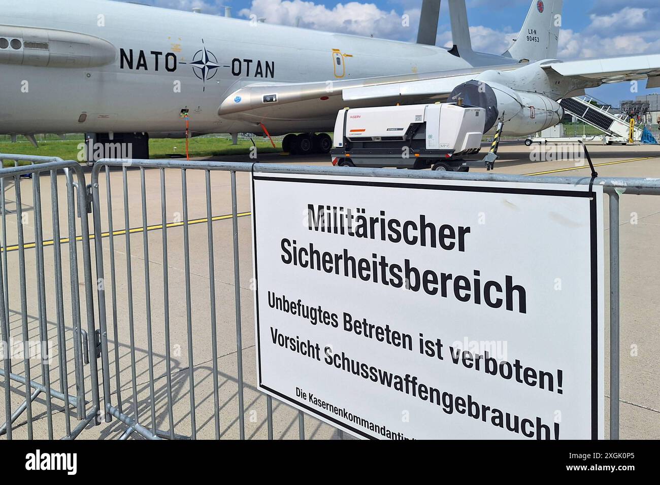 Schönefeld, Brandeburgo, Deutschland, 07.06.2024: ExpoCenter-Aeroporto: Internationale Luft- und Raumfahrtausstellung Berlin ILA: DAS Airborne Early Warning and Control System, kurz AWACS ist ein fliegendes Radarsystem der NATO auf Basis einer modifizierter Boeing 707-Maschine. Im Vordergrund steht ein Schild mit der Aufschrift: Militärischer Sicherheitsbereich - Unbefugtes Betreten ist verboten Vorsicht Schusswaffengebraucht die NATO betreibt auf der Air base Geilenkirchen eine flotte von derzeit 14 dieser Maschinen. Die Bordbesatzung der AWACS besteht in der Regel aus 16 Soldaten verschiedener Foto Stock