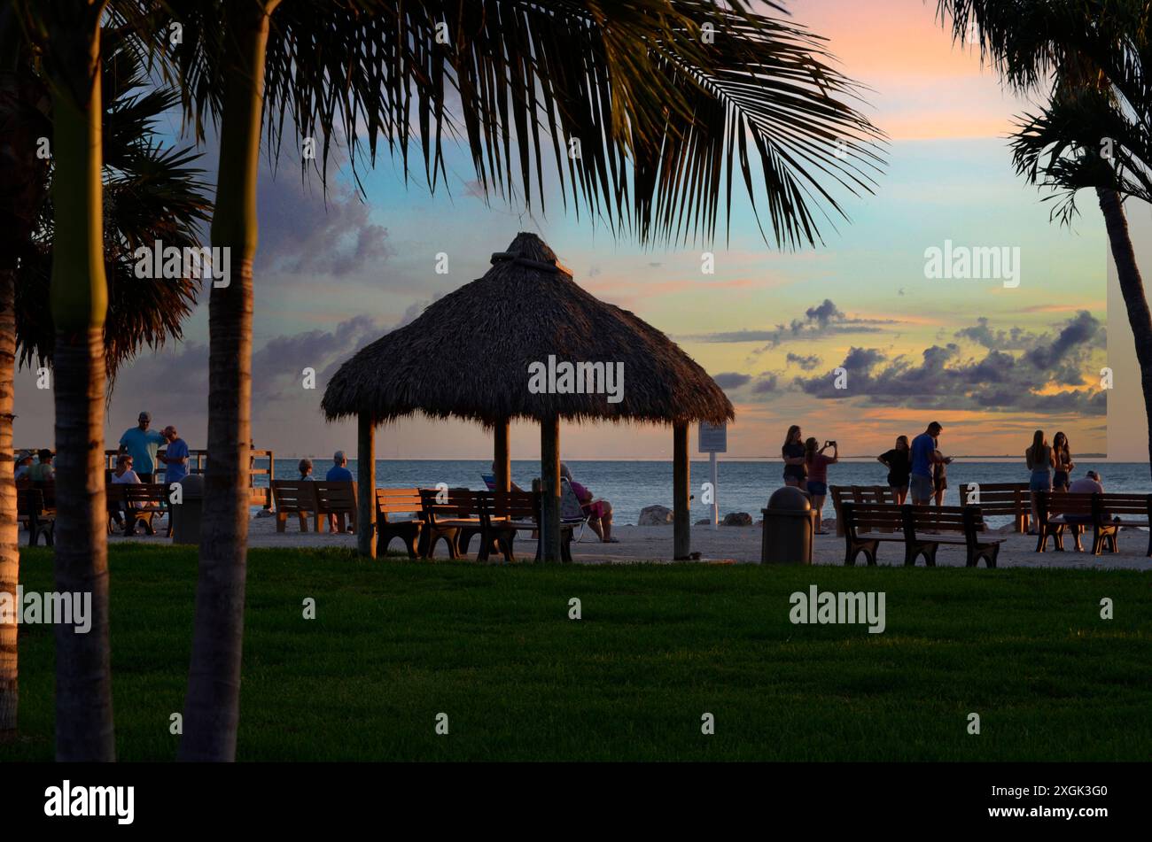 La gente si riunisce al tramonto per una festa in spiaggia Foto Stock