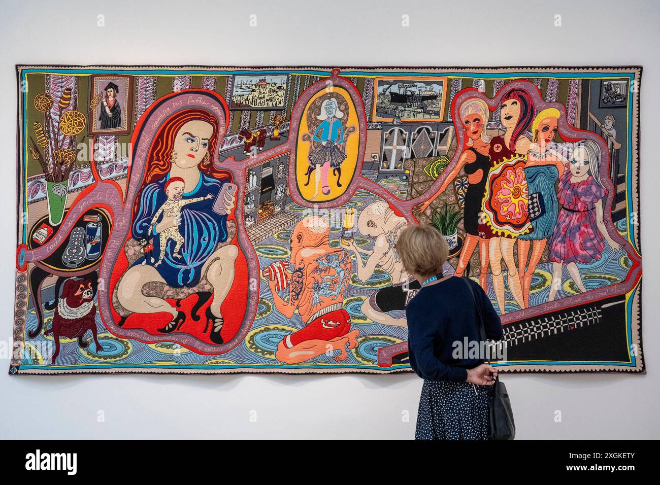 Londra, Regno Unito. 9 luglio 2024. Un membro dello staff con "The Adoration of the Cage Fighters, 2012, in anteprima di "Grayson Perry: The Vanity of Small Differences", 2012, una nuova mostra presso Pitzhanger Manor & Gallery a Ealing, West London. Sei arazzi su larga scala dell'artista vincitore del Turner Prize, ispirati al progresso di William Hogarth (la storia di Tom Rakewell nel XVIII secolo a Londra), sono in mostra dove Hogarth 's A Rake's Progress è stata acquistata dalla moglie di Sir John Soane 222 anni fa per essere esposta a Pitzhanger. La mostra si svolge dal 10 luglio all'8 dicembre 2024. Credito: S Foto Stock