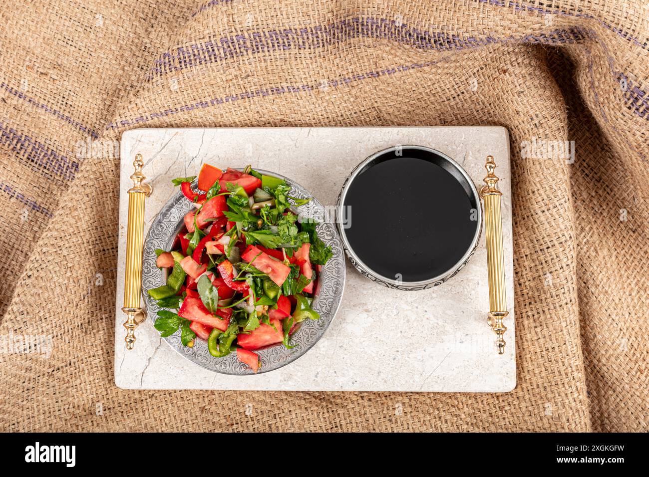 Sciroppo di melograno e insalata. Una ragazza che versa sciroppo di melograno sull'insalata di stagione. Foto Stock