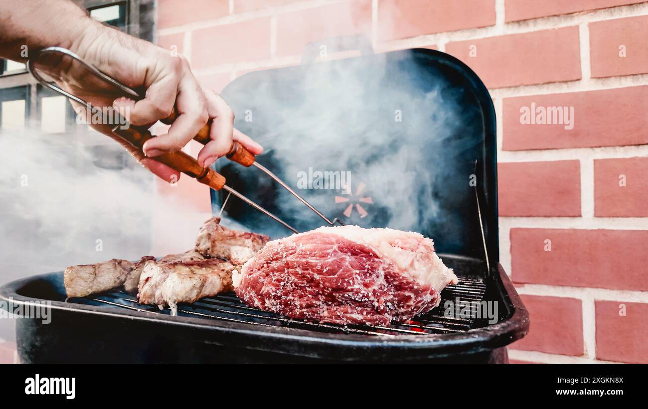 Primo piano della festa di cucina al barbecue nel cortile di casa. barbecue estivo all'aperto Foto Stock