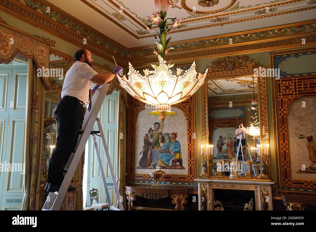 I preparativi finali sono fatti nella Centre Room, dove i membri del personale della Royal Collection Trust tendono ad un lampadario, nell'ala est di Buckingham Palace, Londra, aperto ai visitatori per la prima volta quest'estate, quando speciali visite guidate del piano principale saranno disponibili per i visitatori a luglio e agosto. Data foto: Lunedì 8 luglio 2024. Foto Stock