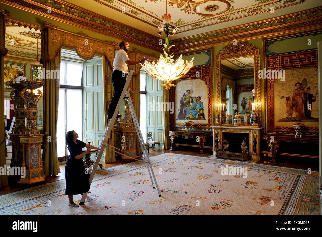 I preparativi finali sono fatti nella Centre Room, dove i membri del personale della Royal Collection Trust tendono ad un lampadario, nell'ala est di Buckingham Palace, Londra, aperto ai visitatori per la prima volta quest'estate, quando speciali visite guidate del piano principale saranno disponibili per i visitatori a luglio e agosto. Data foto: Lunedì 8 luglio 2024. Foto Stock