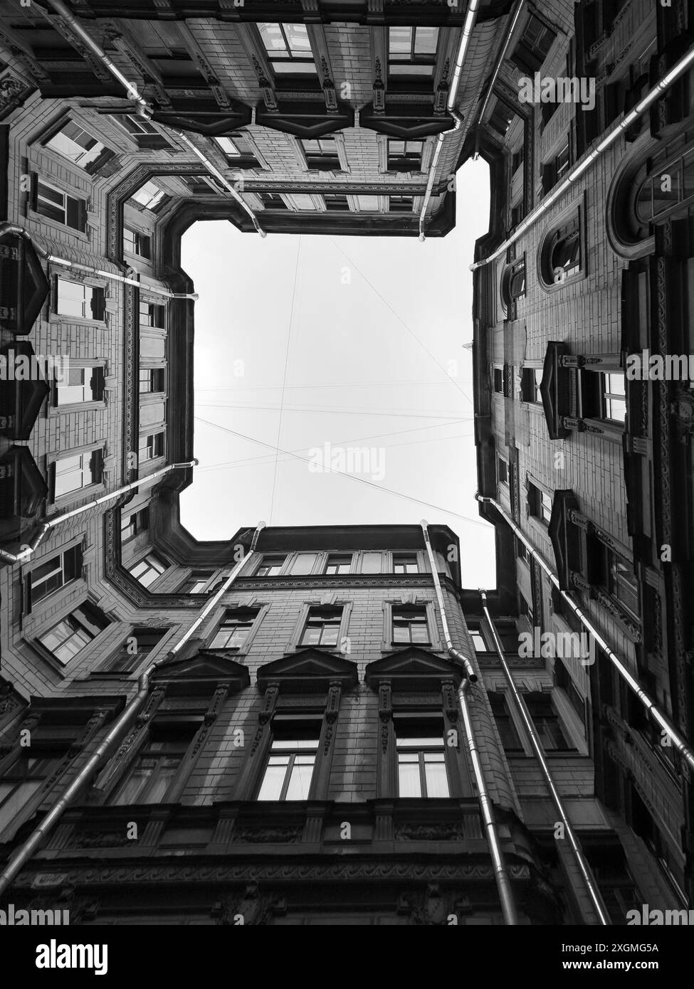 Foto in bianco e nero ad angolo basso per catturare i dettagli architettonici di edifici storici, evidenziando simmetria, finestre e design classico. Foto Stock