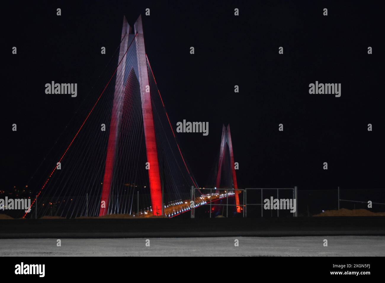 Ponte illuminato di notte con luci rosse e un design architettonico sorprendente Foto Stock