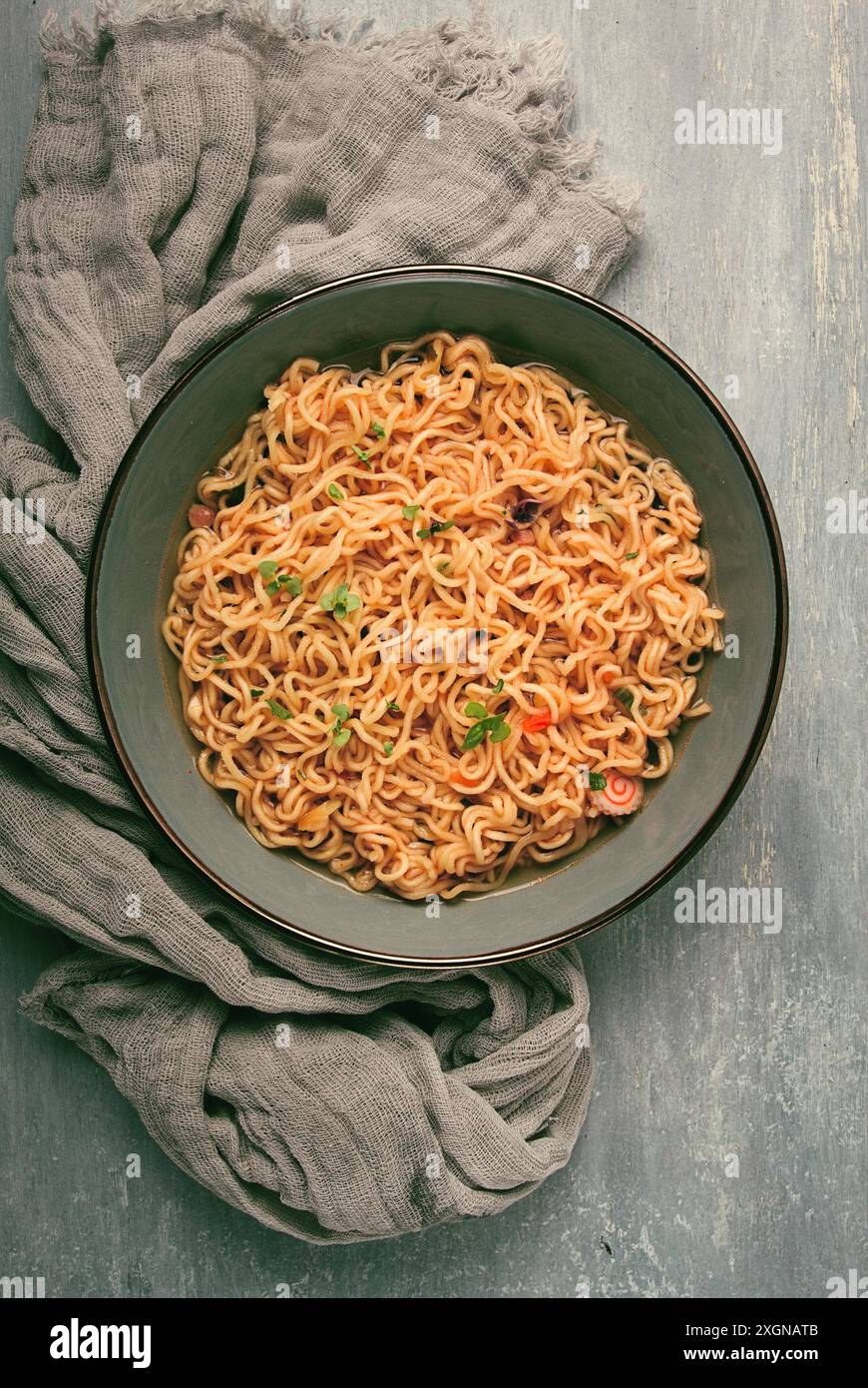 Spaghetti istantanei, in una ciotola, su un tavolo grigio, vista dall'alto, niente persone Foto Stock