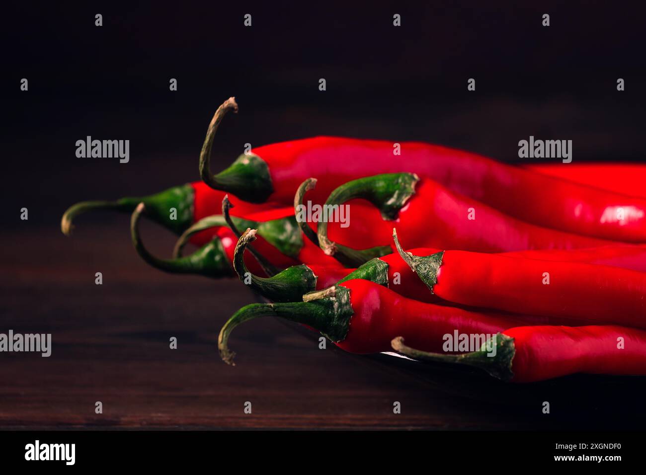 Mazzo di peperoncino rosso caldo, primo piano, su sfondo scuro, attenzione selettiva, nessuna persona, concetto, background alimentare, immagine tonificata Foto Stock