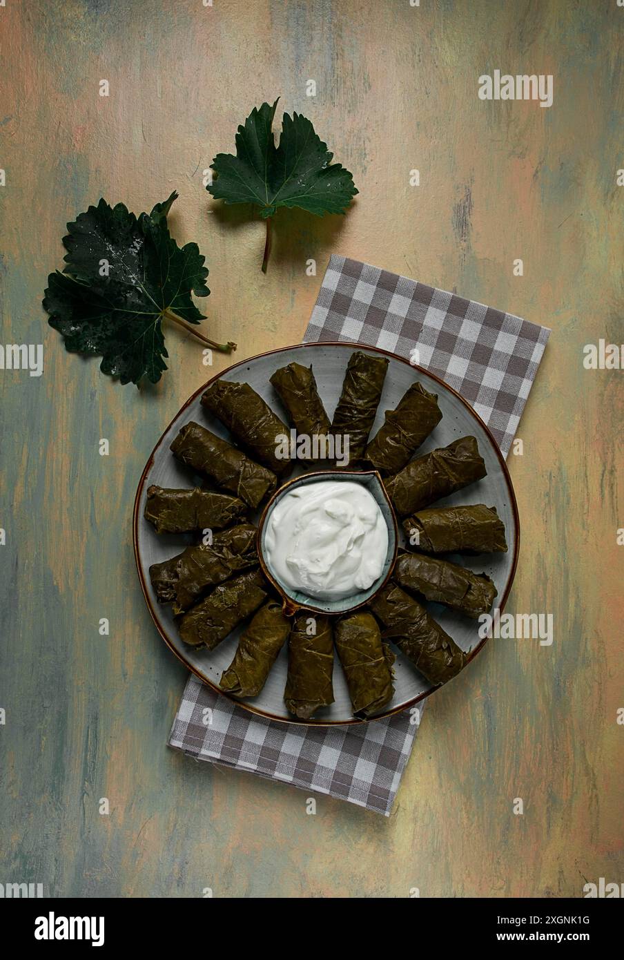 Dolma, involtini di cavolo in foglie d'uva, piatto tradizionale armeno, con salsa bianca, vista dall'alto, primo piano, messa a fuoco selettiva Foto Stock