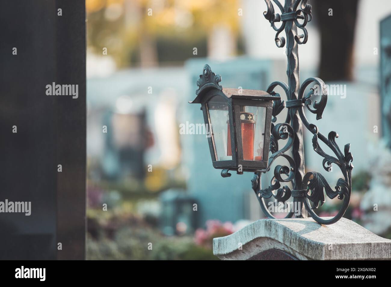 Candela in una lanterna di ferro su una tomba in un cimitero Foto Stock