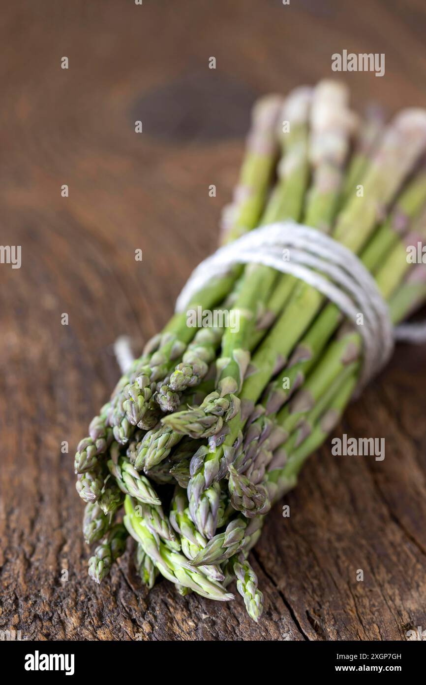 Asparagi verdi selvatici su legno Foto Stock
