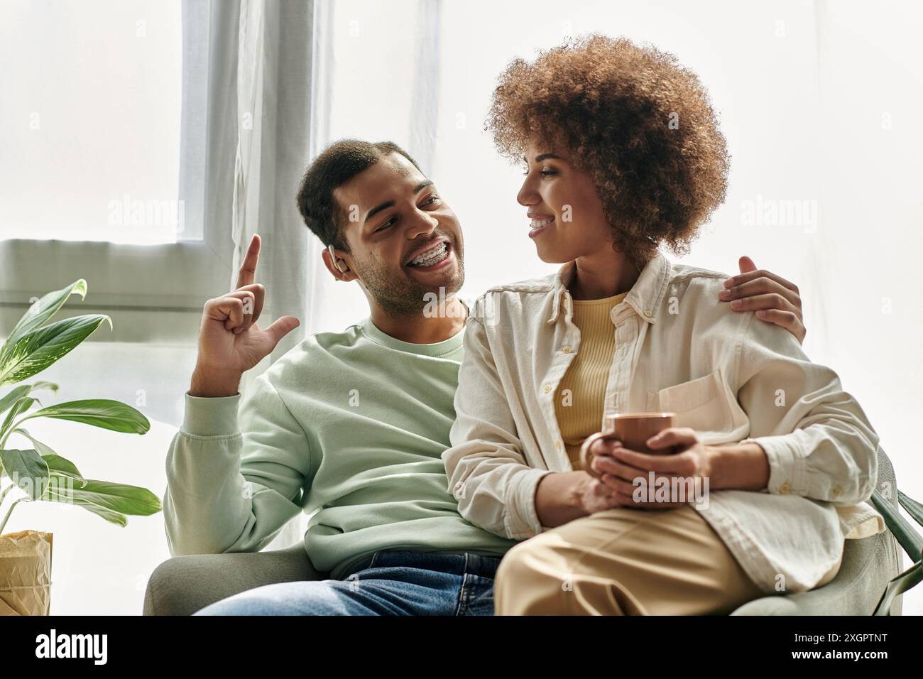 Una coppia afroamericana usa il linguaggio dei segni per comunicare a casa, mostrando una profonda connessione e comprensione. Foto Stock