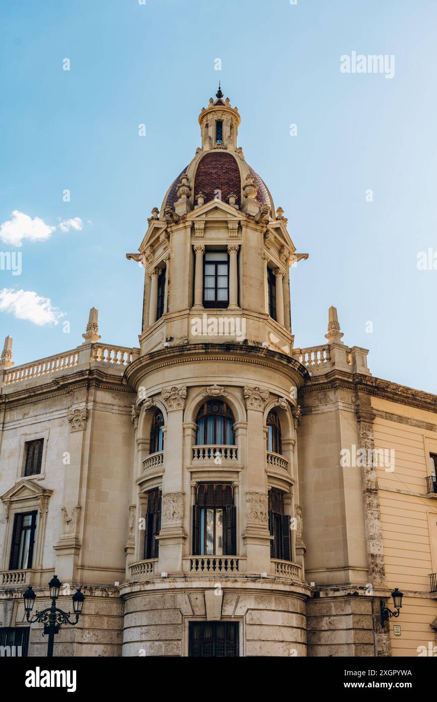 Primo piano di una torre ornata su un edificio storico di Valencia. L'architettura dettagliata e il cielo luminoso evidenziano il patrimonio culturale e la bellezza artistica della città. Foto Stock