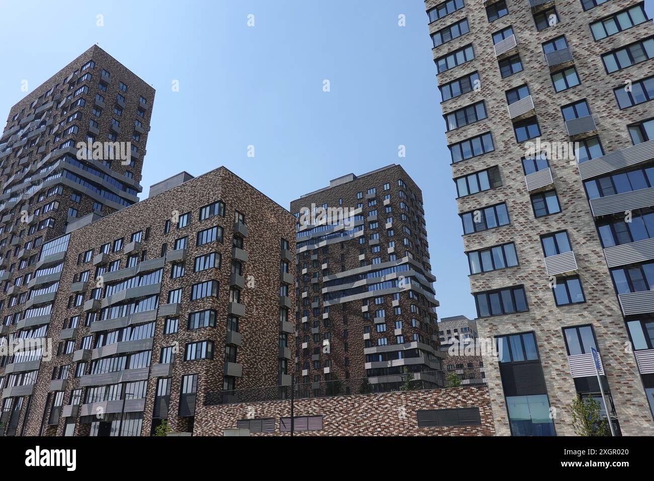 Vista dal basso degli alti e moderni edifici della città con molte finestre costruite nel gruppo urbano Foto Stock