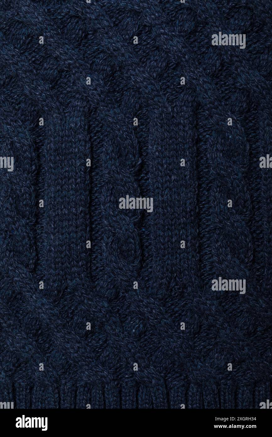 Primo piano di un pullover in maglia a cavo blu navy con sfondo testurizzato Foto Stock