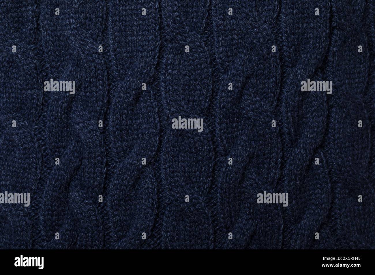 Primo piano di un pullover in maglia a cavo blu navy con sfondo testurizzato Foto Stock