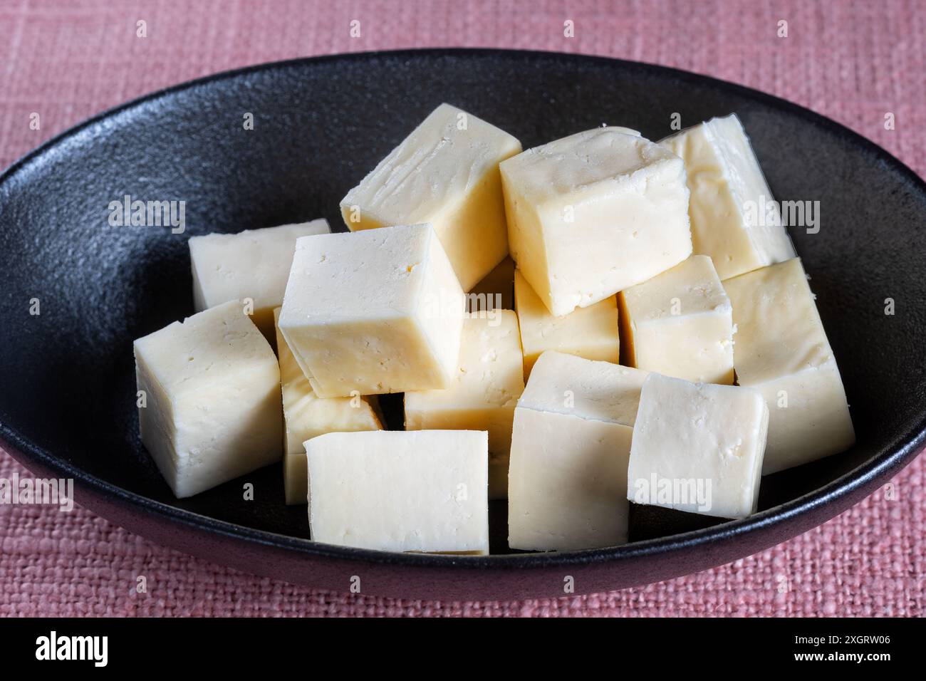 Una ciotola di formaggio morbido Paneer fatto in Gran Bretagna. Il formaggio e' fatto con latte intero ed e' usato in piatti e cucine tradizionali indiane Foto Stock