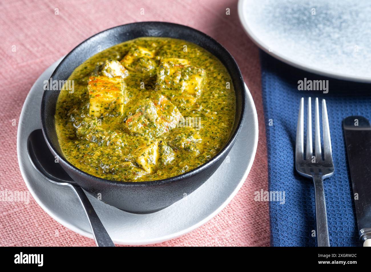 Bristol, Regno Unito. Un contorno di Saag Paneer o paneer Palak servito al tavolo. Un piatto tradizionale della cucina indiana e pakistana. Popolare nel Regno Unito Foto Stock