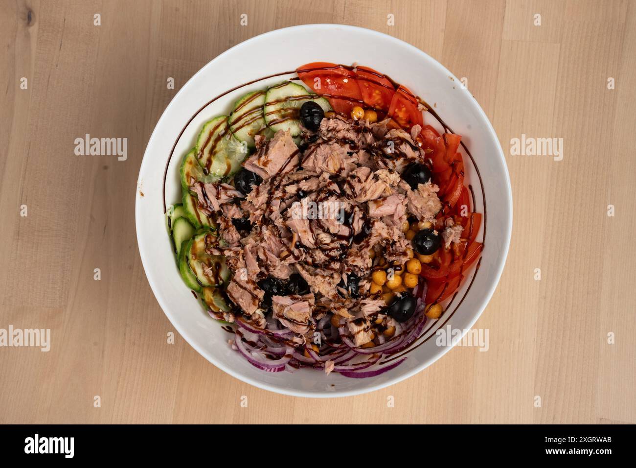 Vista dall'alto di una ciotola per insalate fresca con pollo croccante, cetrioli, pomodori e cipolle rosse Foto Stock