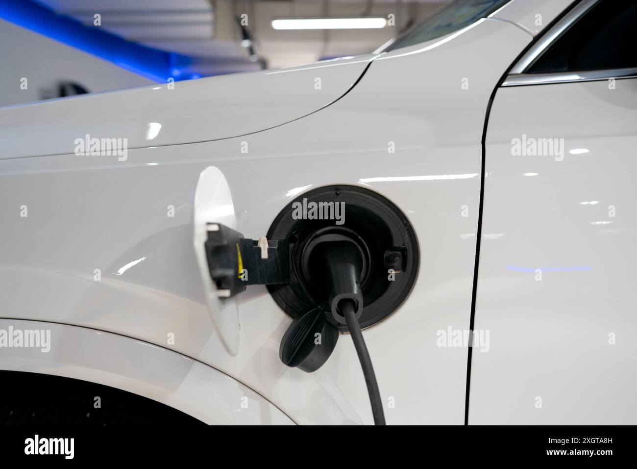 Parcheggio di veicoli elettrici o EV presso la stazione di ricarica e cavo di alimentazione collegato. Caricare l'alimentazione alla batteria EV o ibrida. Energia verde ed eco Foto Stock