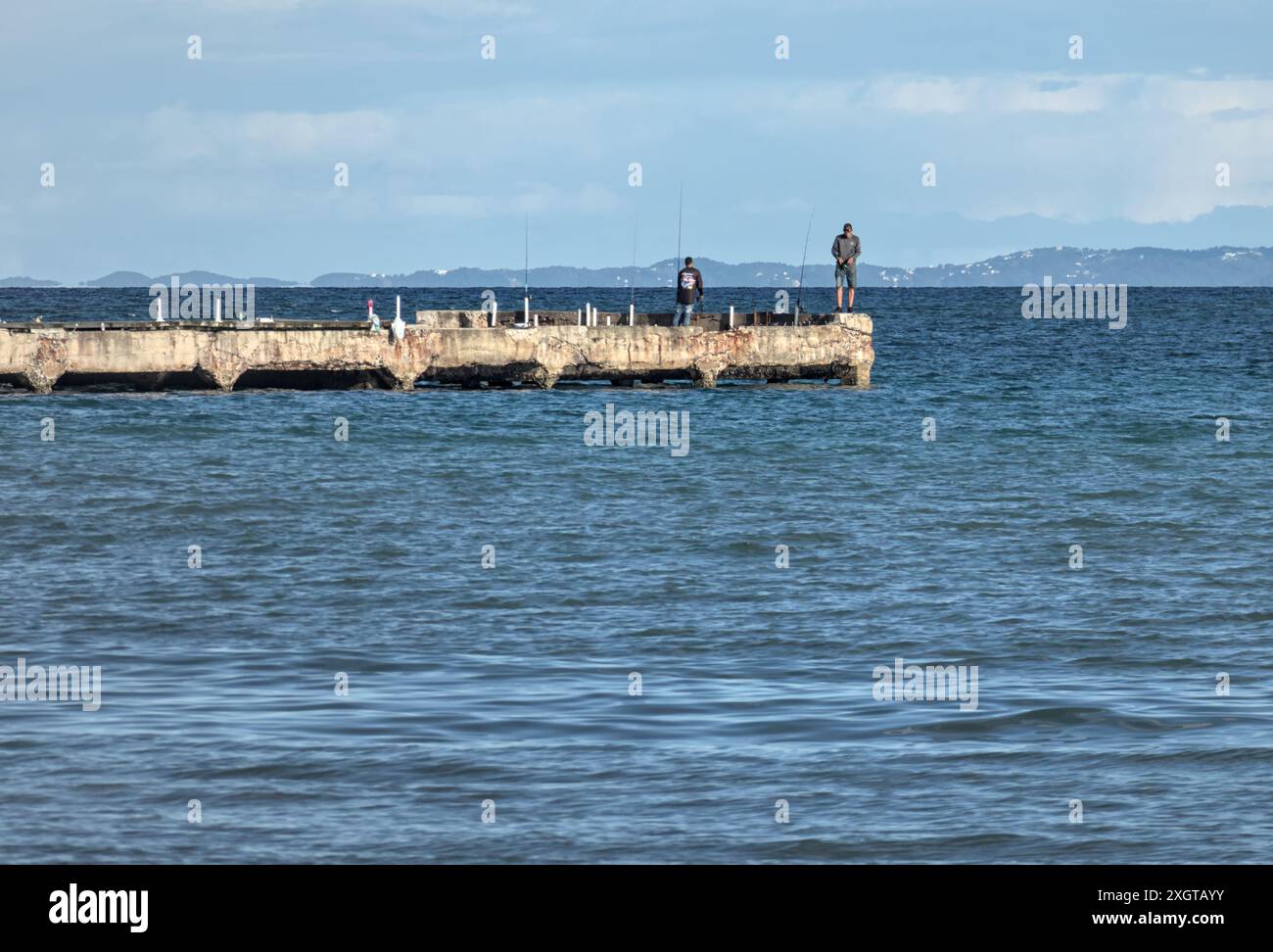 uomini che pescano su un molo a punta santiago humacao porto rico (viaggio in mare caraibico) Foto Stock