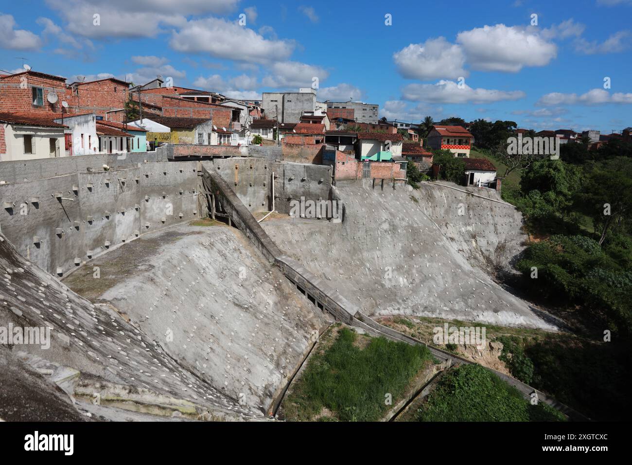 Catu, bahia, brasile - 20 giugno 2024: Veduta di un muro di cemento per proteggere le case su una collina nella città di Catu. Foto Stock