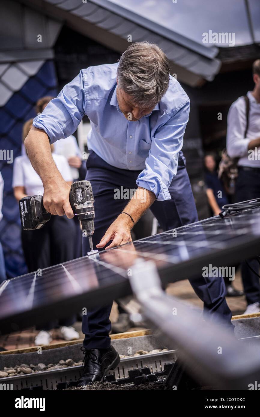 Der Bundesminister fuer Wirtschaft und Klimaschutz Robert Habeck Buendnis 90/ die Gruenen auf Sommerreise durch Deutschland. Hier in Bochum, 10.07.2024 beim Besuch eines Dachdeckers mit Solardach-Elementen Fotografiert im Auftrag des BMWK Bochum Deutschland *** il Ministro federale dell'economia e della protezione del clima Robert Habeck Buendnis 90 Die Gruenen in un tour estivo attraverso la Germania qui a Bochum, 10 07 2024 visitare un conciatetto con elementi solari del tetto fotografato per conto di BMWK Bochum Germania Copyright: xDominikxButzmannxBMWKxphotothek.dex Foto Stock