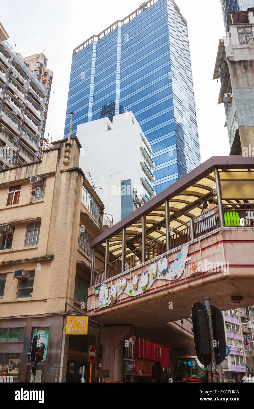 Hong Kong - 15 luglio 2017: La gente comune cammina per la strada sotto alti grattacieli. Vista verticale sulla strada del quartiere centrale di Hong Kong Foto Stock