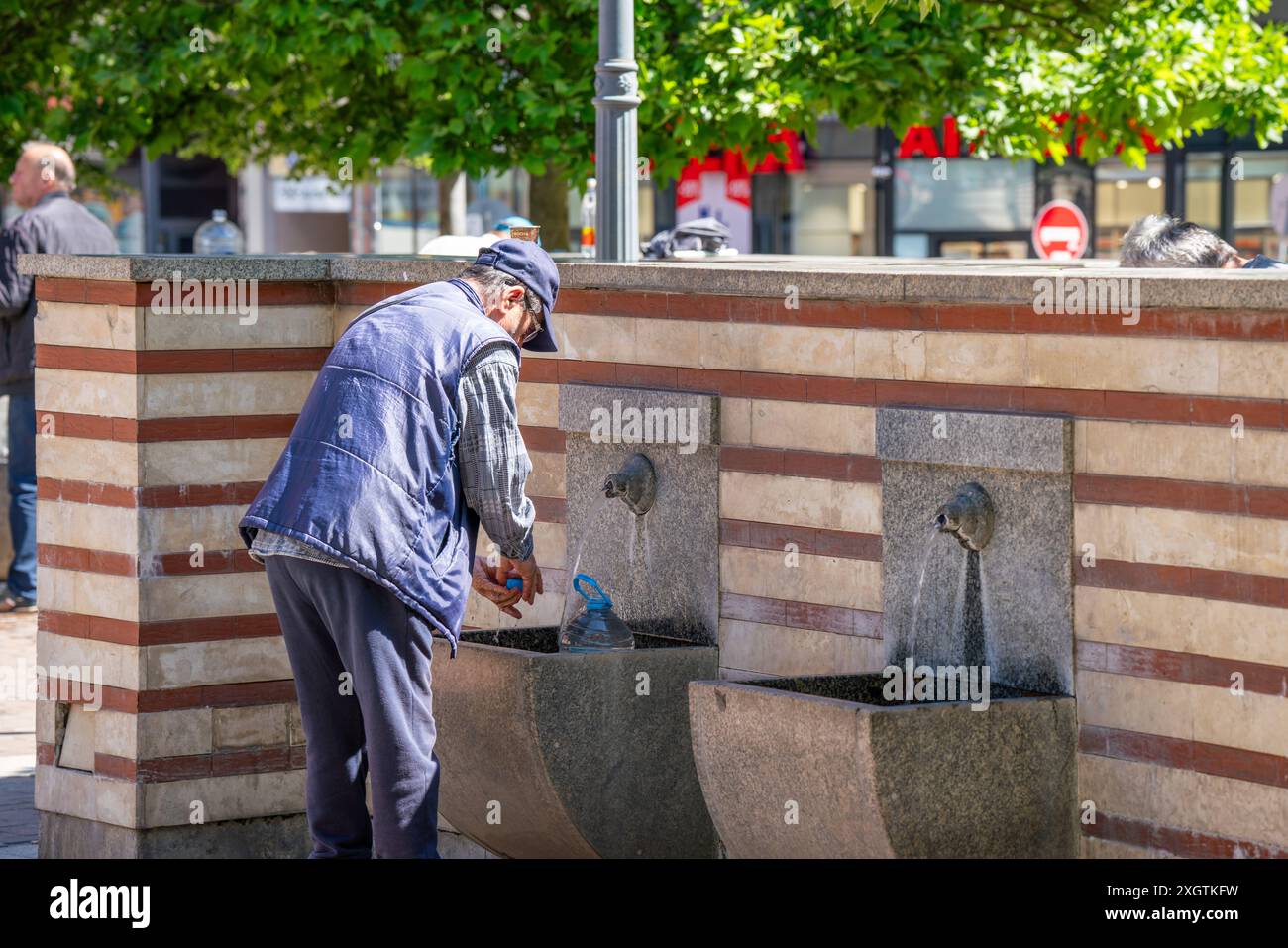 Sofia, Bulgaria. 25 maggio 2024. Un uomo riempie una bottiglia di plastica con acqua nella famosa sorgente di acqua minerale calda nel centro della città Foto Stock