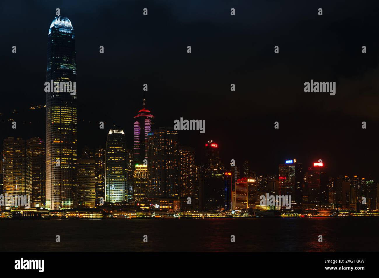 Hong Kong - 20 luglio 2017: Città di Hong Kong di notte, moderno paesaggio urbano costiero con grattacieli illuminati Foto Stock