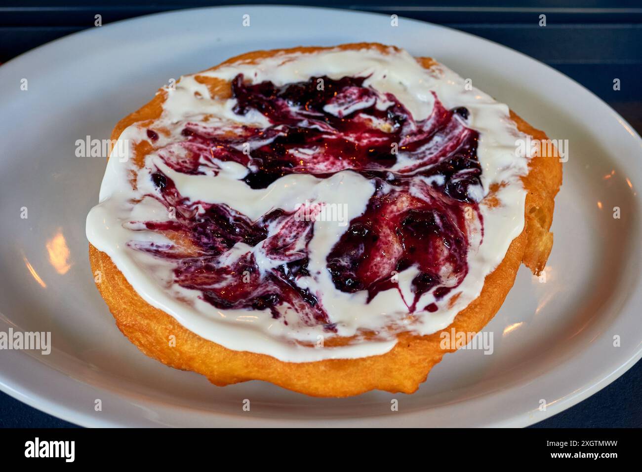 Langhi con panna acida e marmellata di mirtilli, un tipico cibo ungherese. Foto Stock