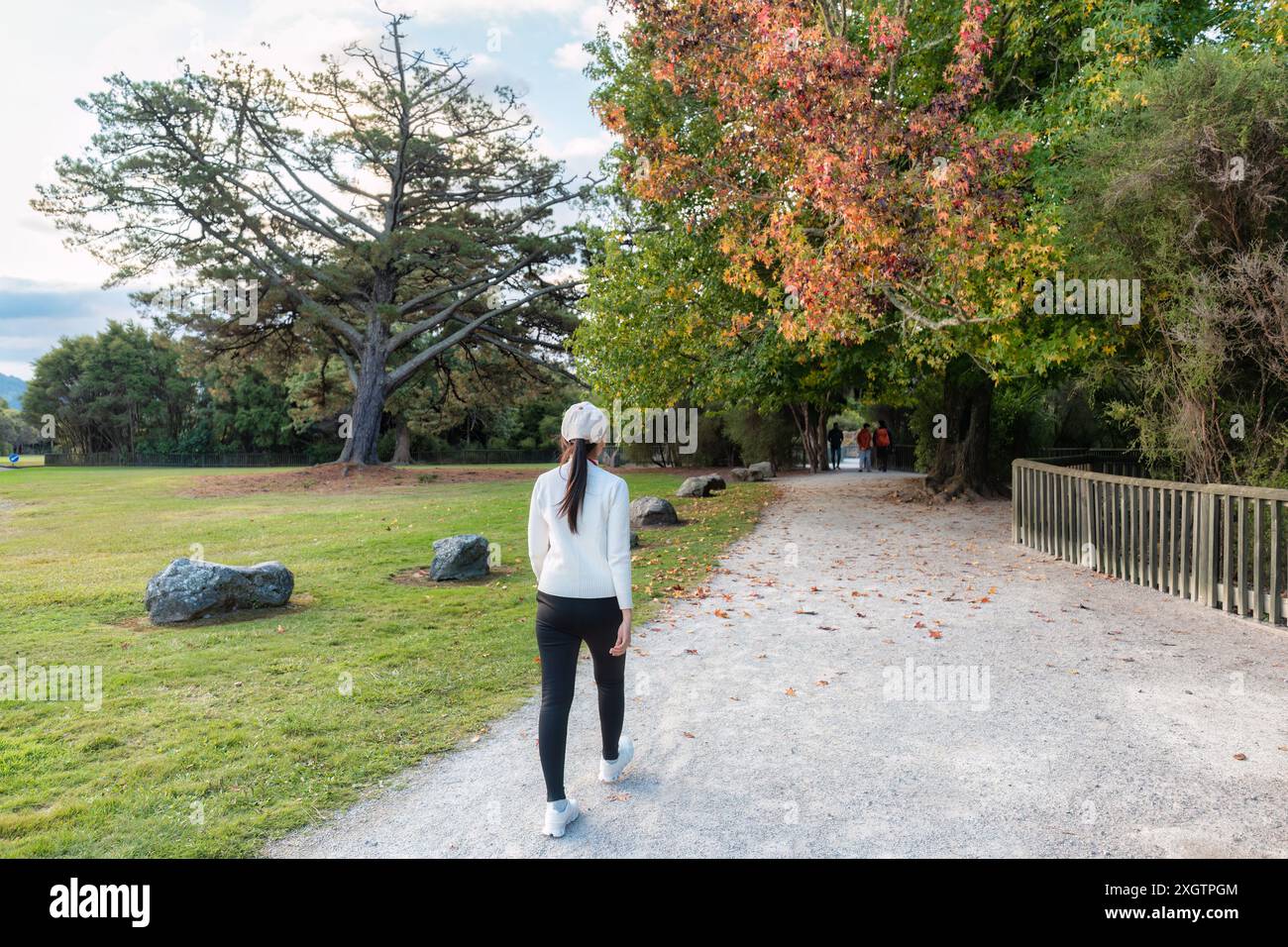 Bella donna asiatica che cammina e si fa esercizio nel parco autunnale di Cornwall Park, Auckland, nuova Zelanda Foto Stock