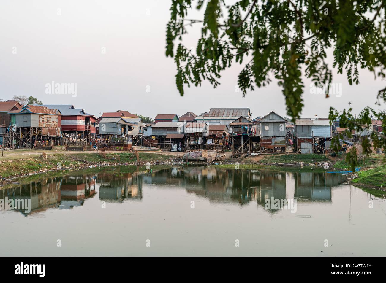 Palafitte costruite sulla riva del fiume, riflettono l'architettura culturale in un piccolo e tranquillo villaggio cambogiano. Foto Stock