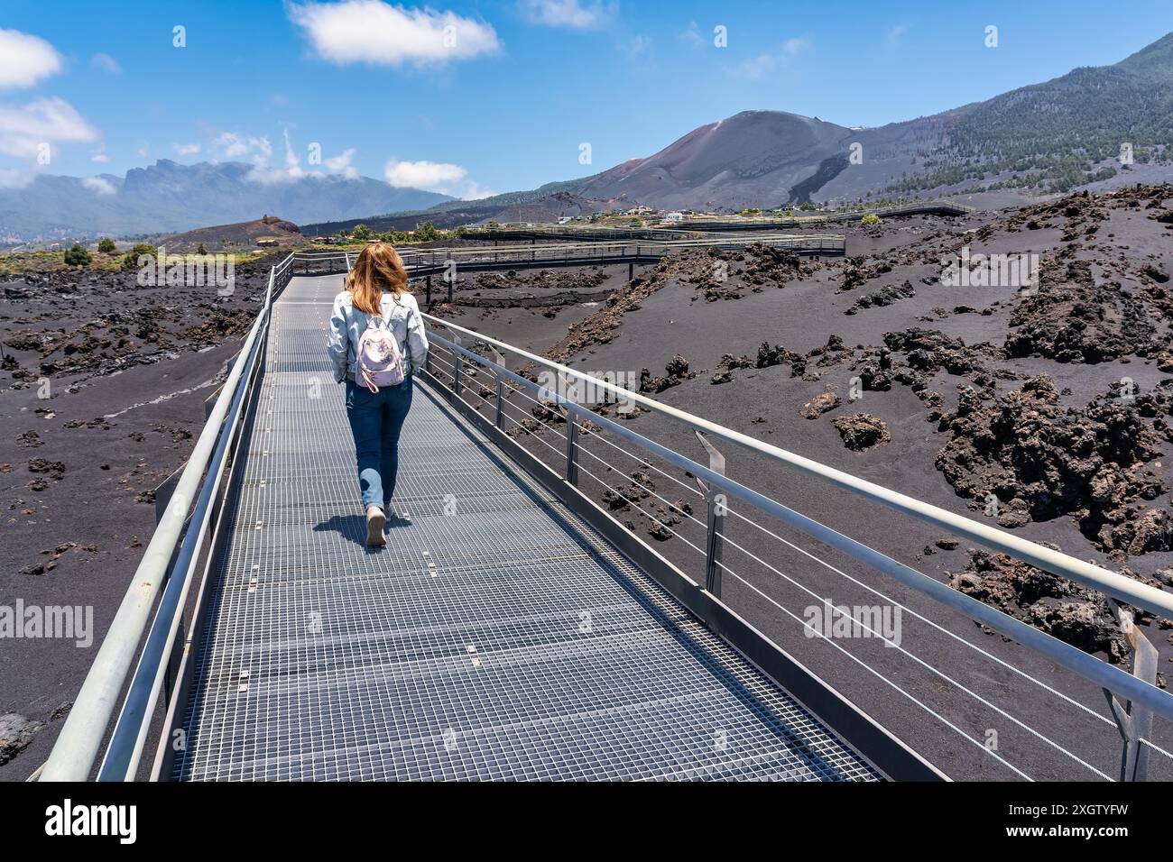 Donna turistica che cammina lungo un sentiero tra rocce e cenere vulcanica sull'isola di la Palma, Isole Canarie. Foto Stock