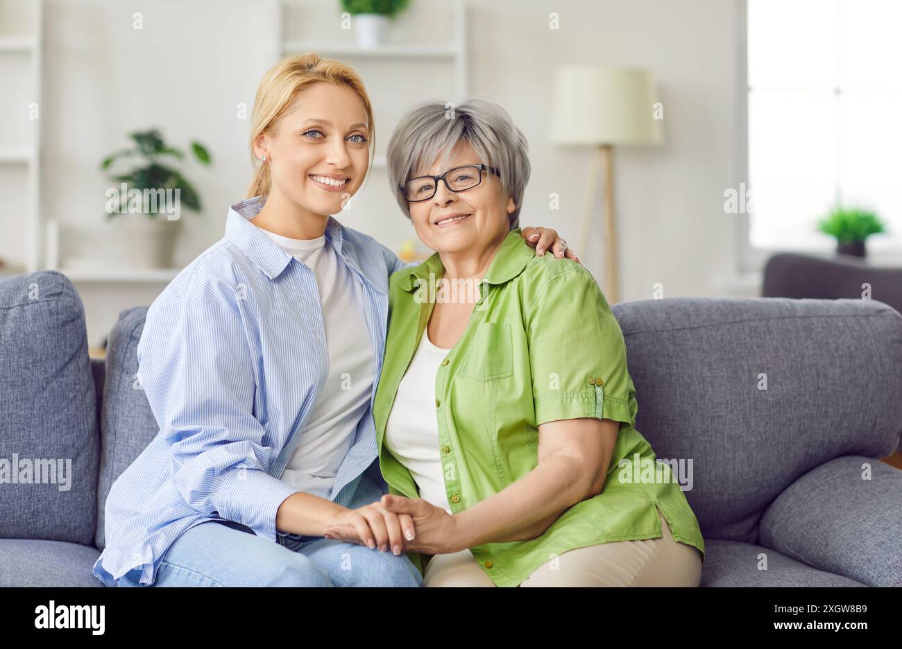 Gentile sorridente amorevole anziana madre matura più anziana, figlia adulta seduta sul divano, premurosa Foto Stock