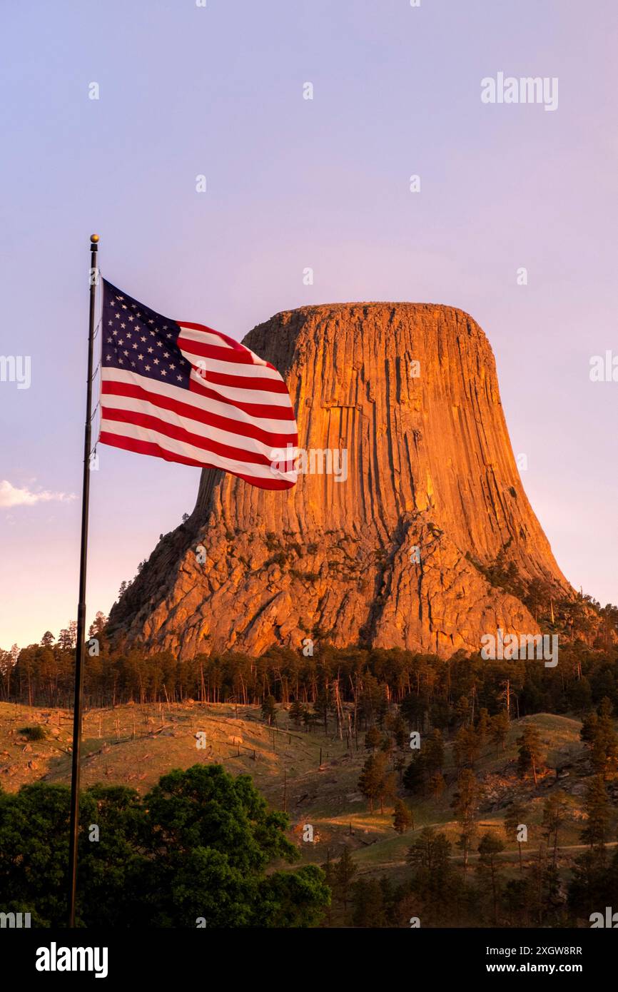 Monumento nazionale della Devils Tower con bandiera americana in primo piano Foto Stock