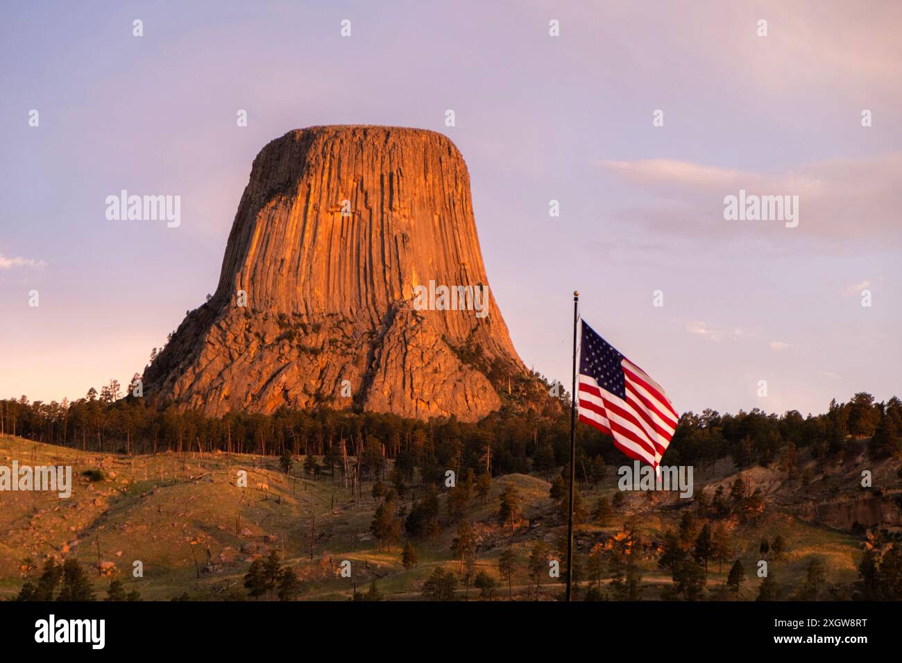 Monumento nazionale della Devils Tower con bandiera americana in primo piano Foto Stock
