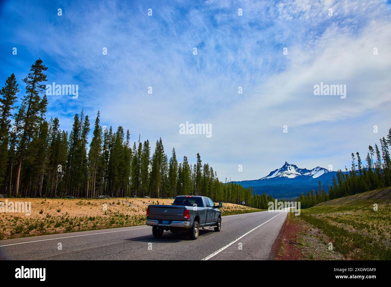 Mountain Road innevata con pick-up in movimento Foto Stock