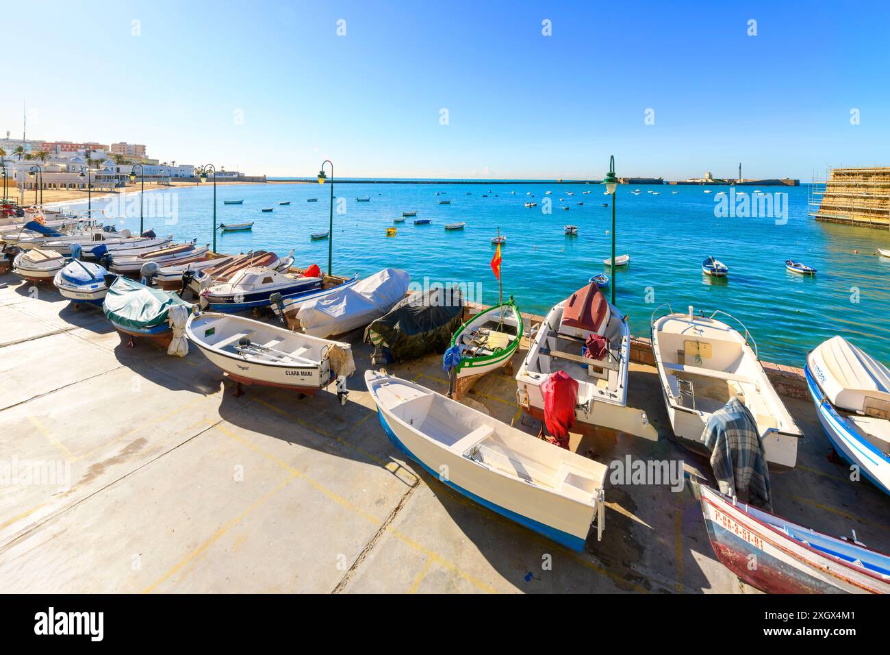 Barche da pesca lungo il porto e nel mare a la Caleta Beach nel centro storico della città andalusa di Cádiz, Spagna. Foto Stock
