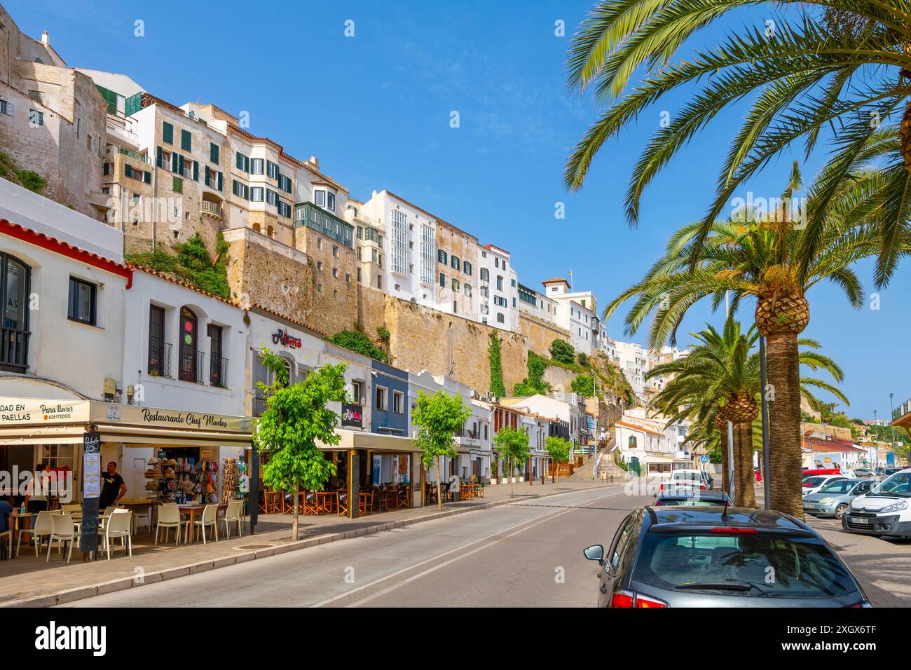 Gli edifici bianchi sulla scogliera con caffè e negozi sul lungomare, al porto di Mahon, sull'isola delle Baleari di Minorca in Spagna. Foto Stock