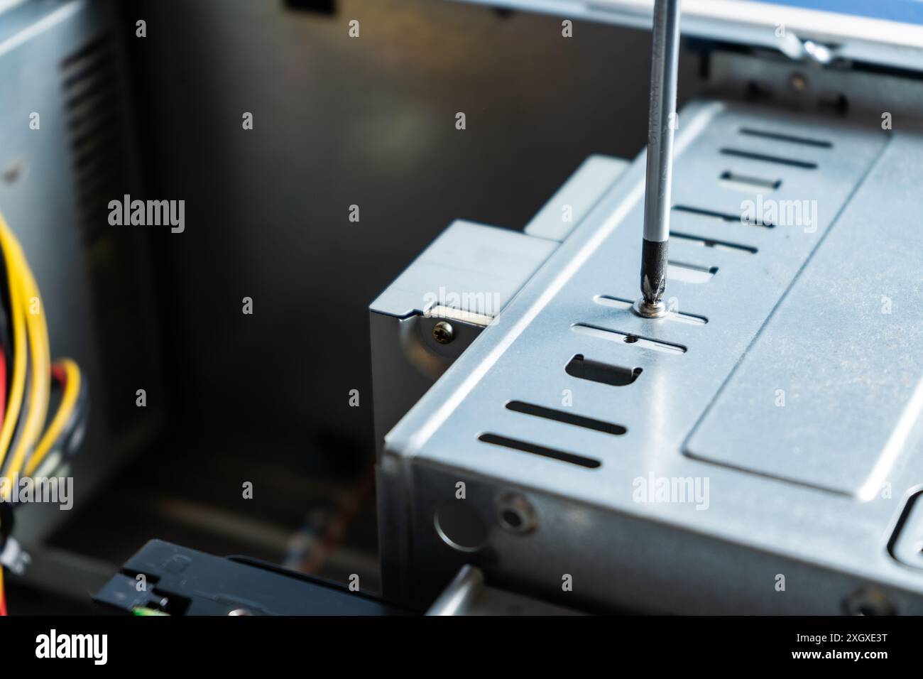 Tecnico PC che regola la vite sul coperchio di un armadio. Lavorare in un armadietto per computer. Foto Stock