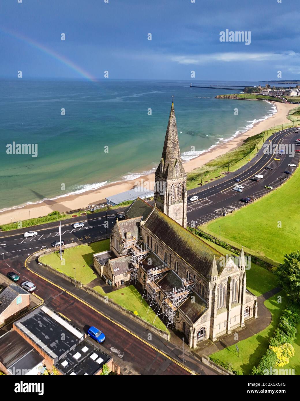 Cullercoats, Northumberland. Regno Unito. 07.07.2024 Rainbow sorge sul Mare del Nord dietro la chiesa di St Georges lungo la costa nord-orientale. 7 luglio Foto Stock