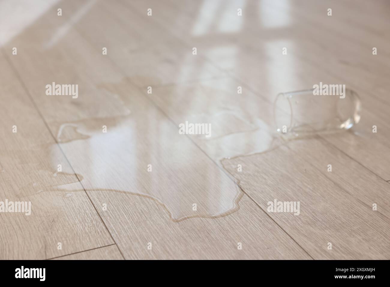 Bicchiere con bibita versata su pavimento in legno Foto Stock