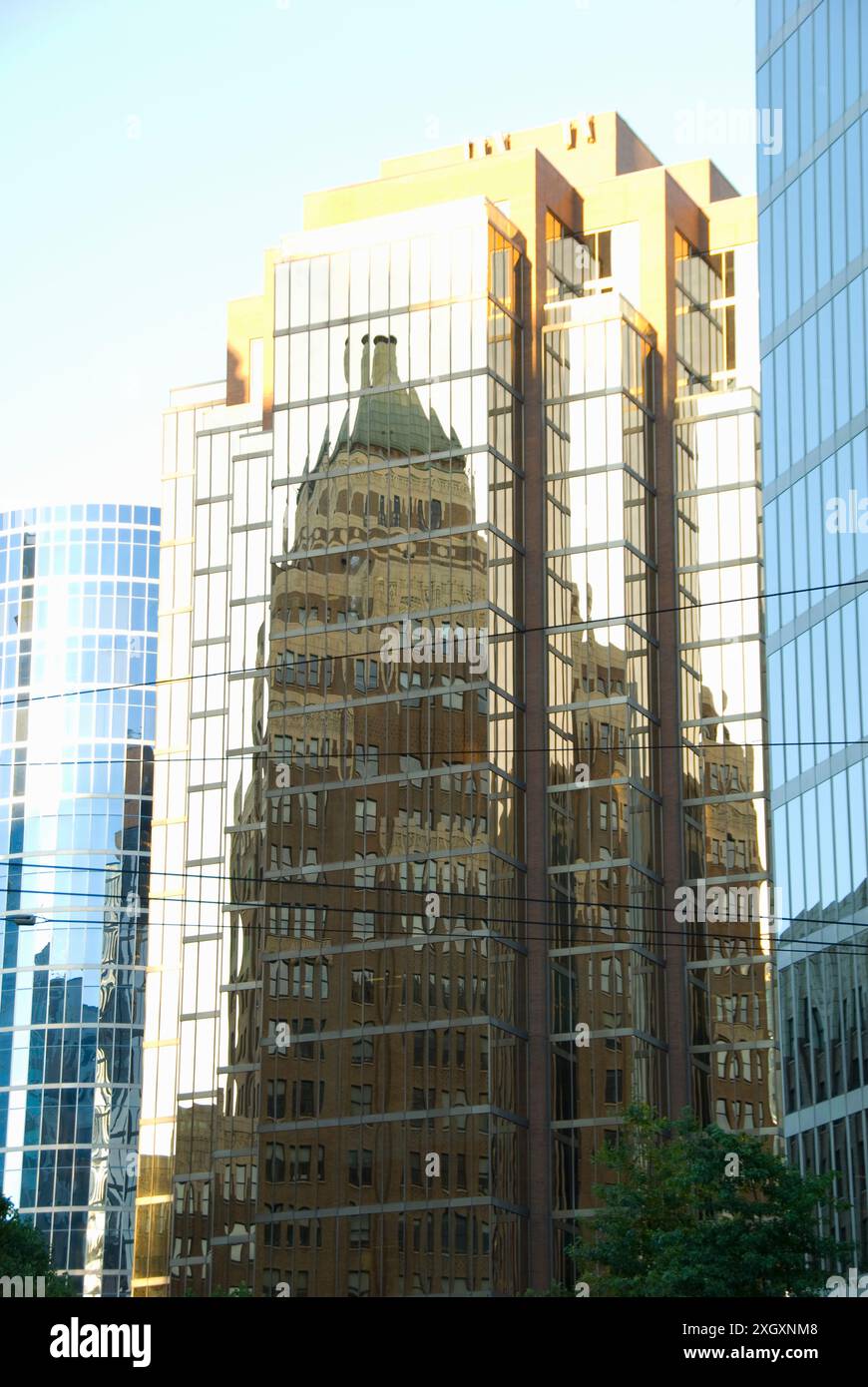 Edifici che si riflettono in un edificio di vetro nel centro della città - Vancouver, BC, Canada Foto Stock
