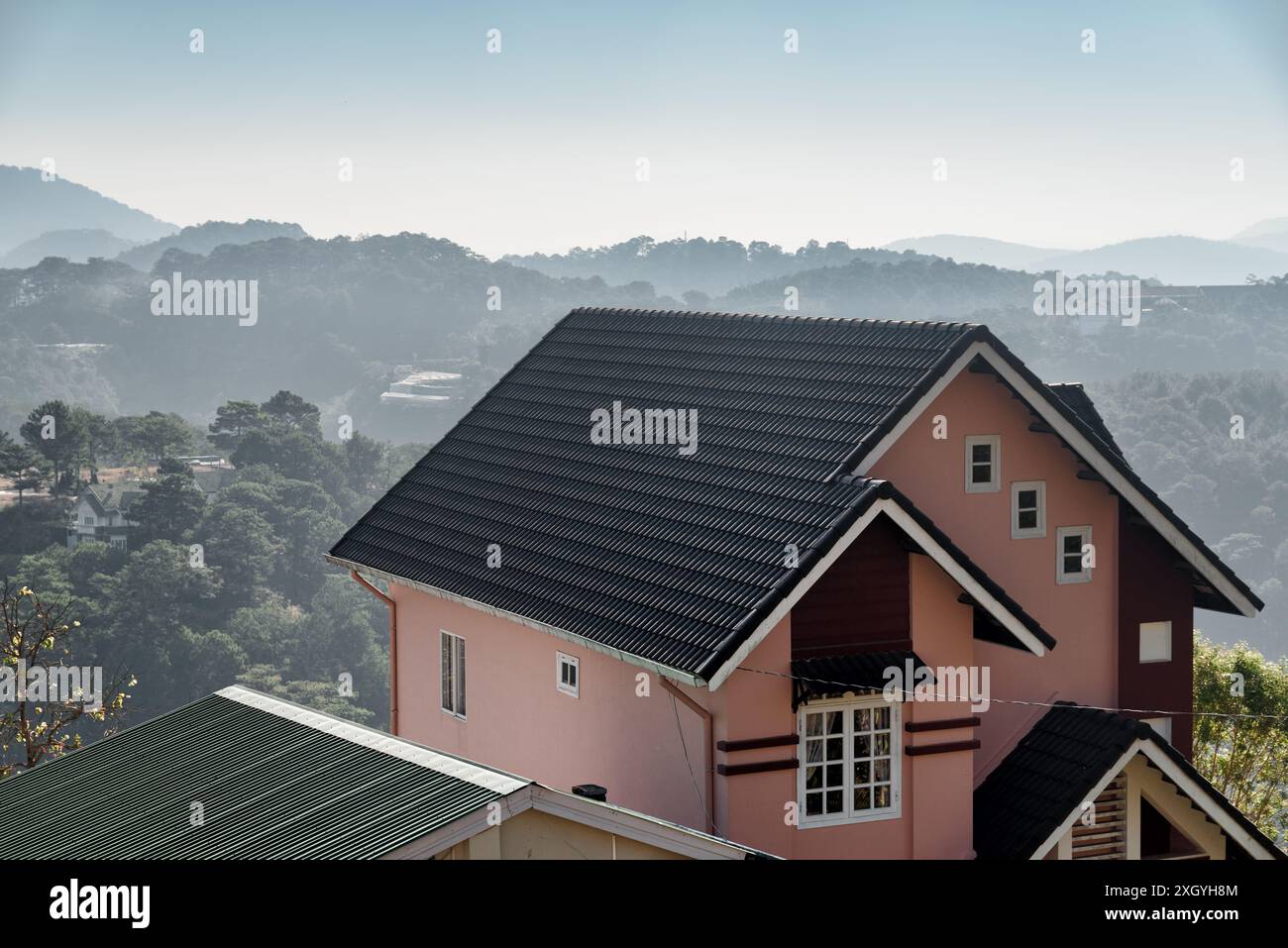 Vista panoramica della casa tra pinete e montagne a Dalat (da Lat) in Vietnam. Paesaggio incredibile al sole mattutino. Foto Stock