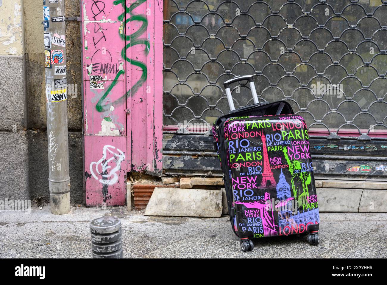 Una valigia abbandonata e rotta in una strada cittadina, Foto Stock