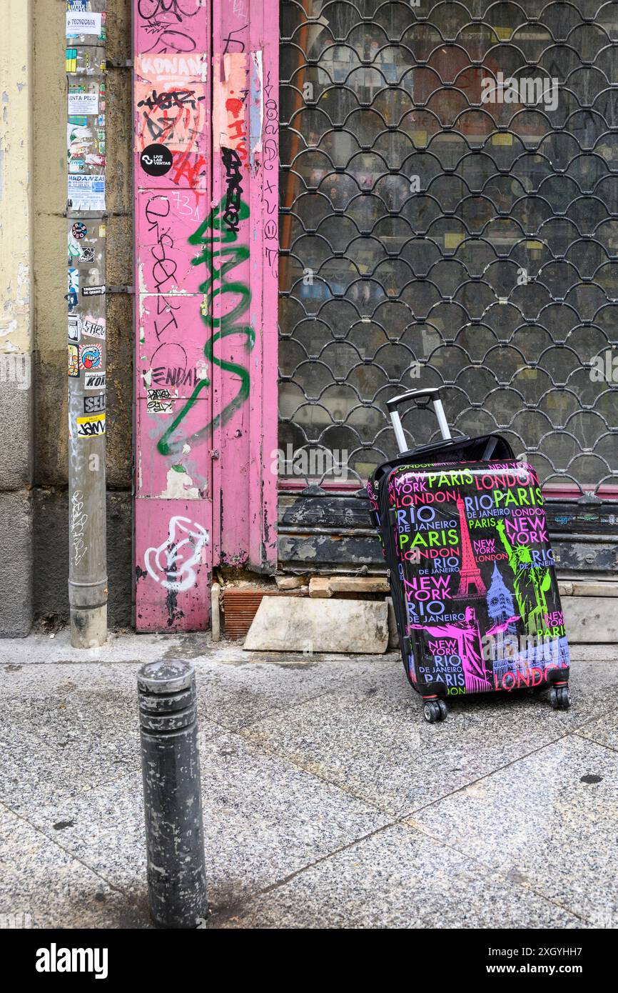 Una valigia abbandonata e rotta in una strada cittadina, Foto Stock