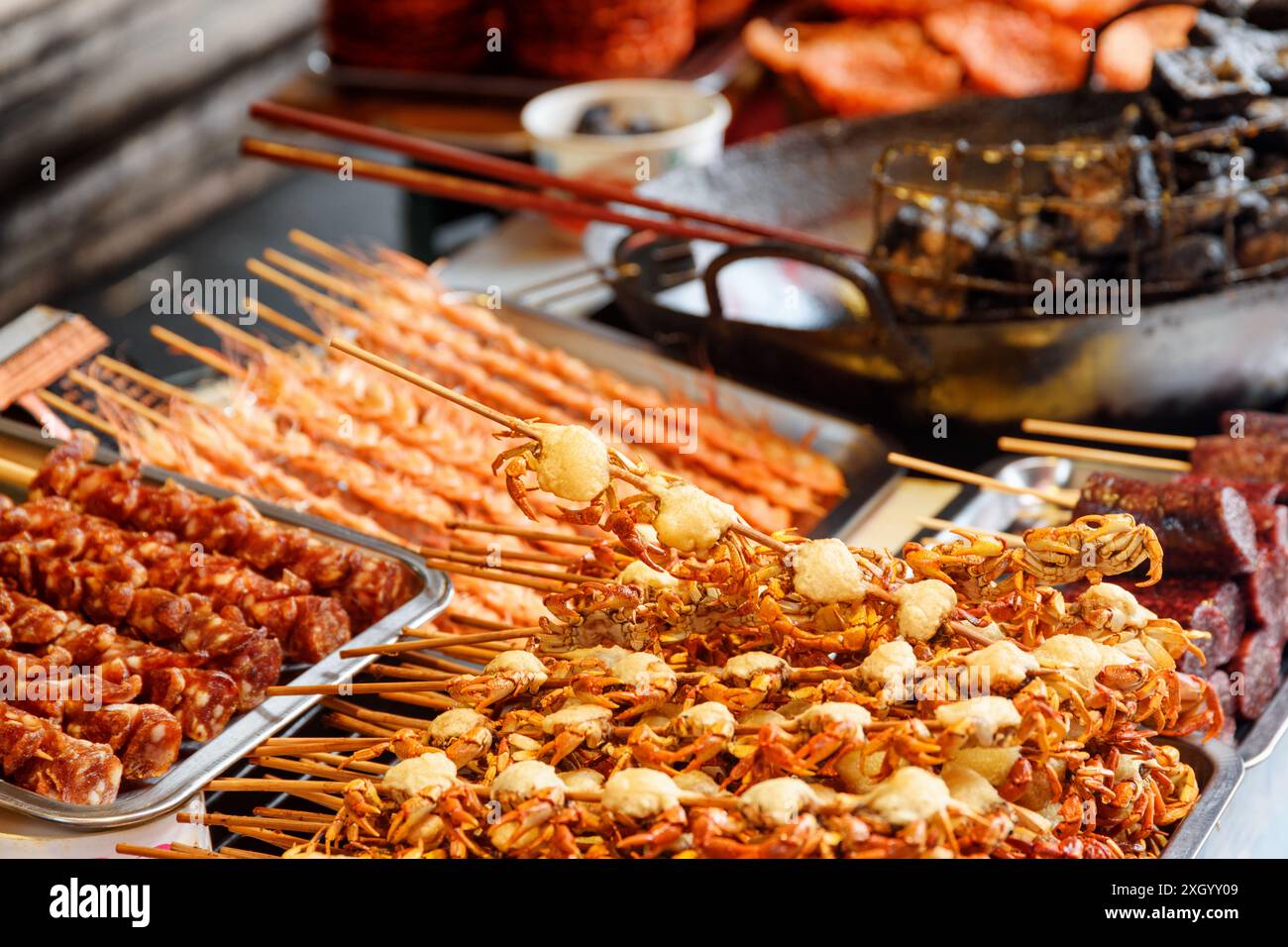 Gustosi spuntini a base di pesce. Granchi grigliati. Cibo di strada asiatico. Foto Stock