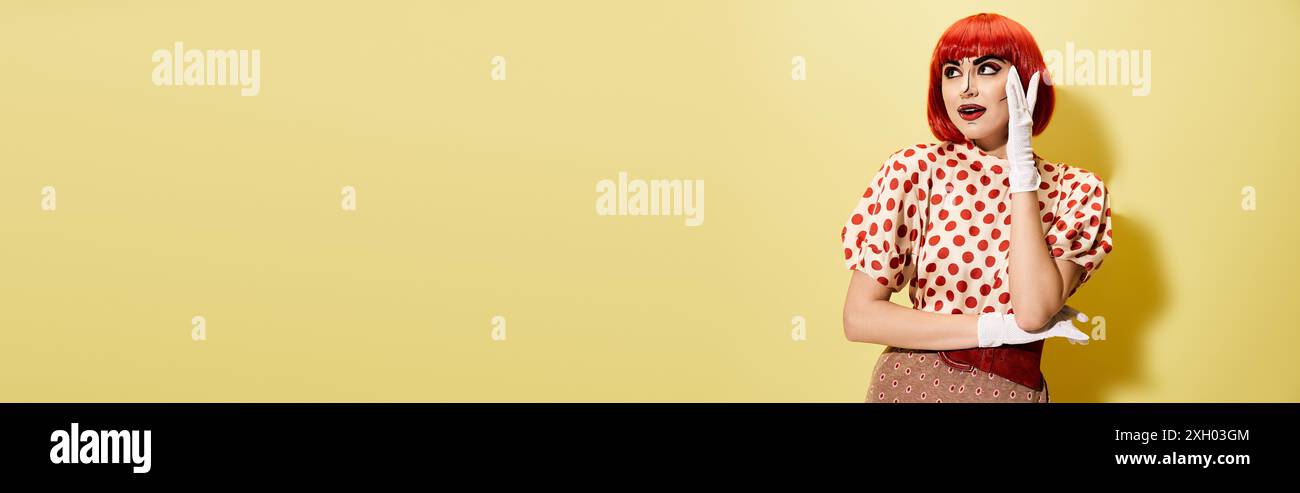 Una vivace rossa in una camicia a pois con un creativo trucco pop art, dà vita alle vibrazioni dei personaggi dei fumetti su uno sfondo giallo. Foto Stock